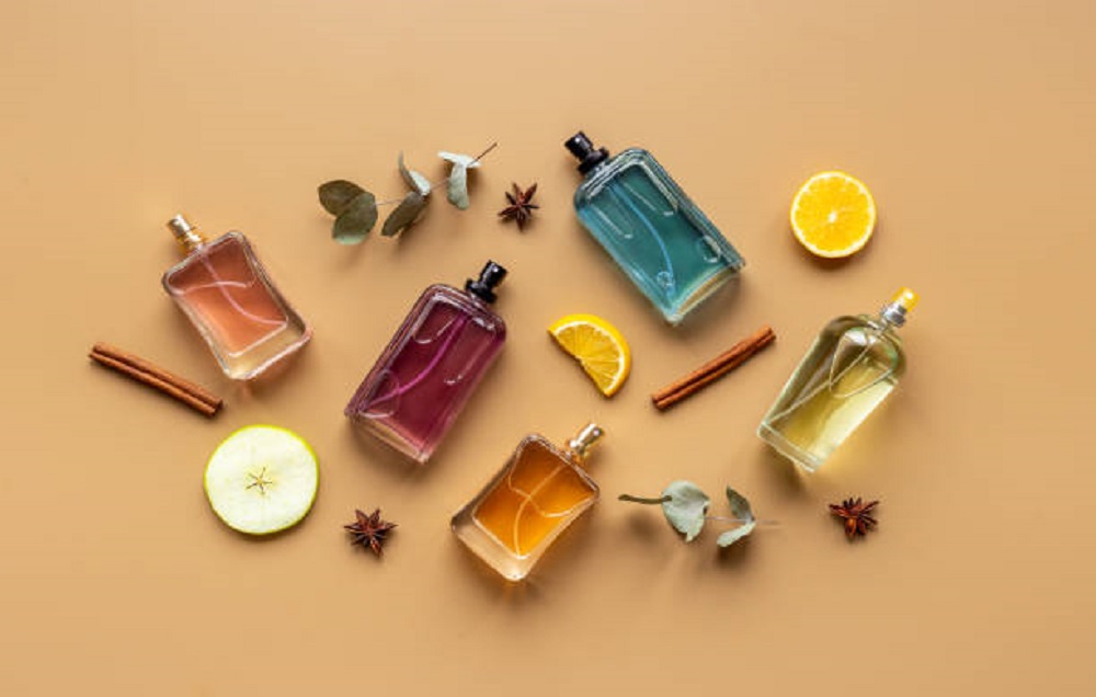 Set of perfume bottles with fragrance spaces and fruits.