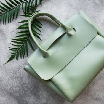 Women's bag made of green leather on a gray concrete background